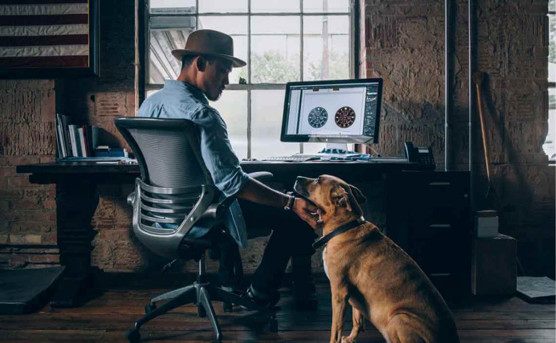 man petting dog in office