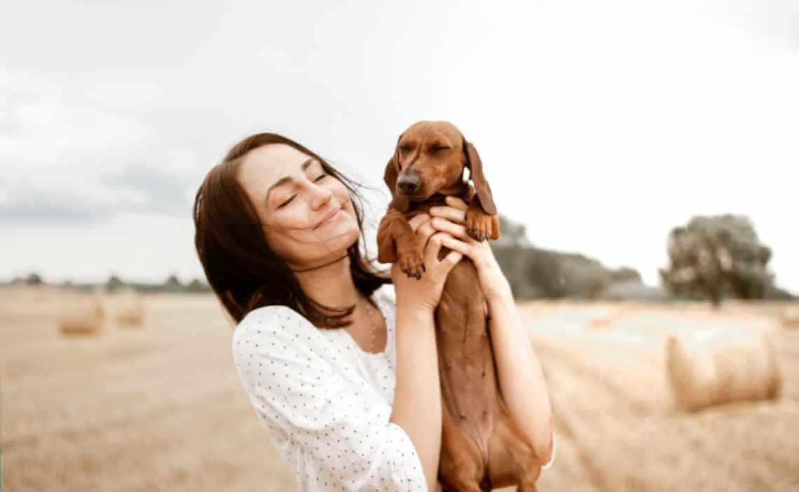 smiling woman with found daschund