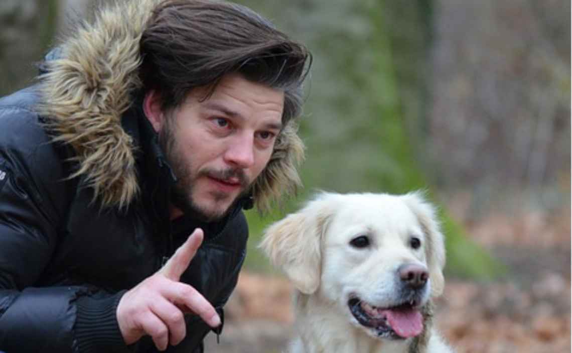 DOG OBEDIENCE TRAINING MAN SQUATTED DOWN TALKING WITH HIS DOG