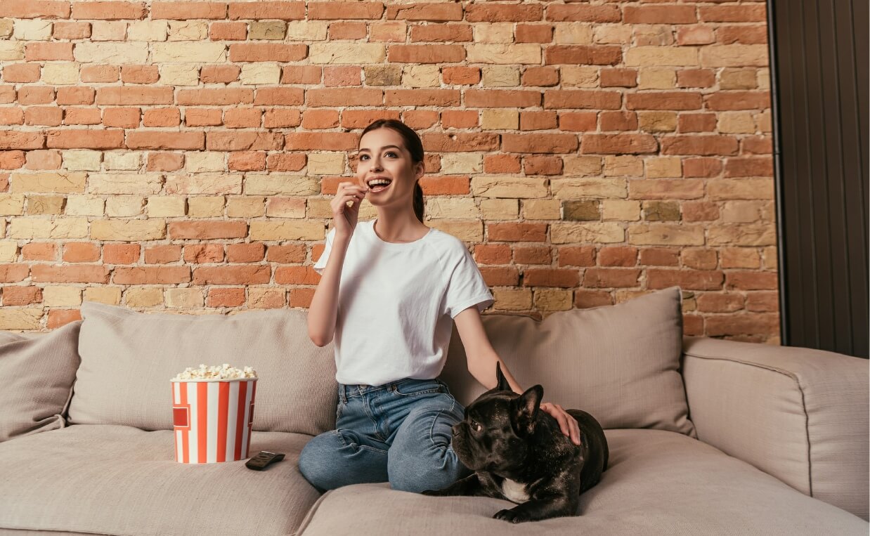 DOG MOVIES woman watching movie eating popcorn black bulldog