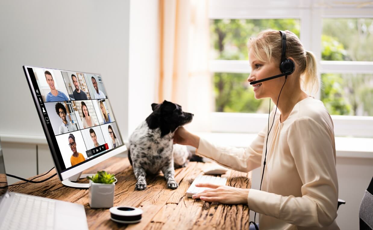 woman on zoom call with dog on desk