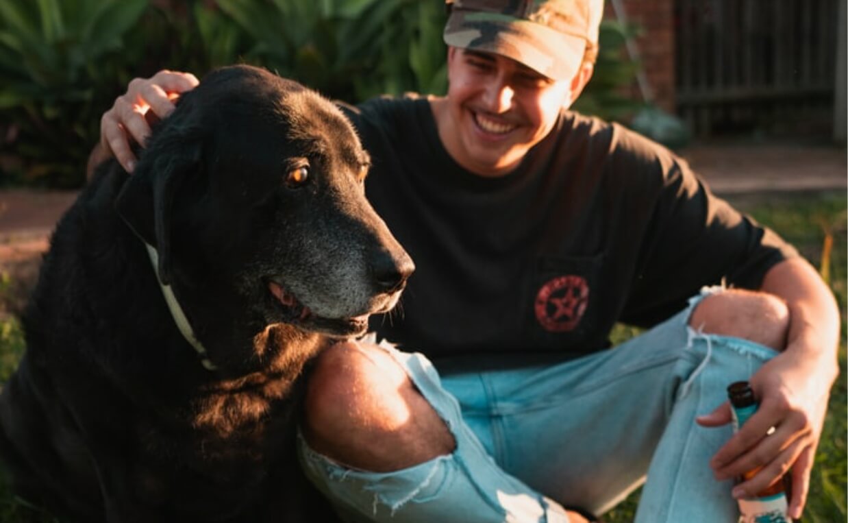 man drinking beer with dog