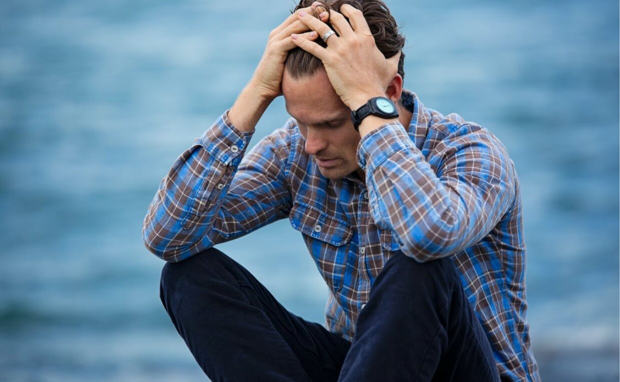 MAN GRIEVING DOG LOSS BLUE BACKGROUND