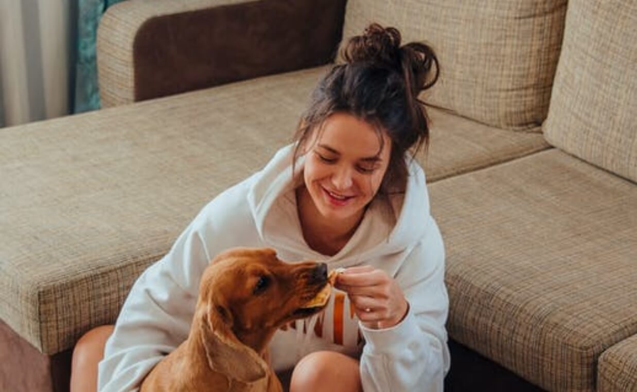 woman feeding dog pizza