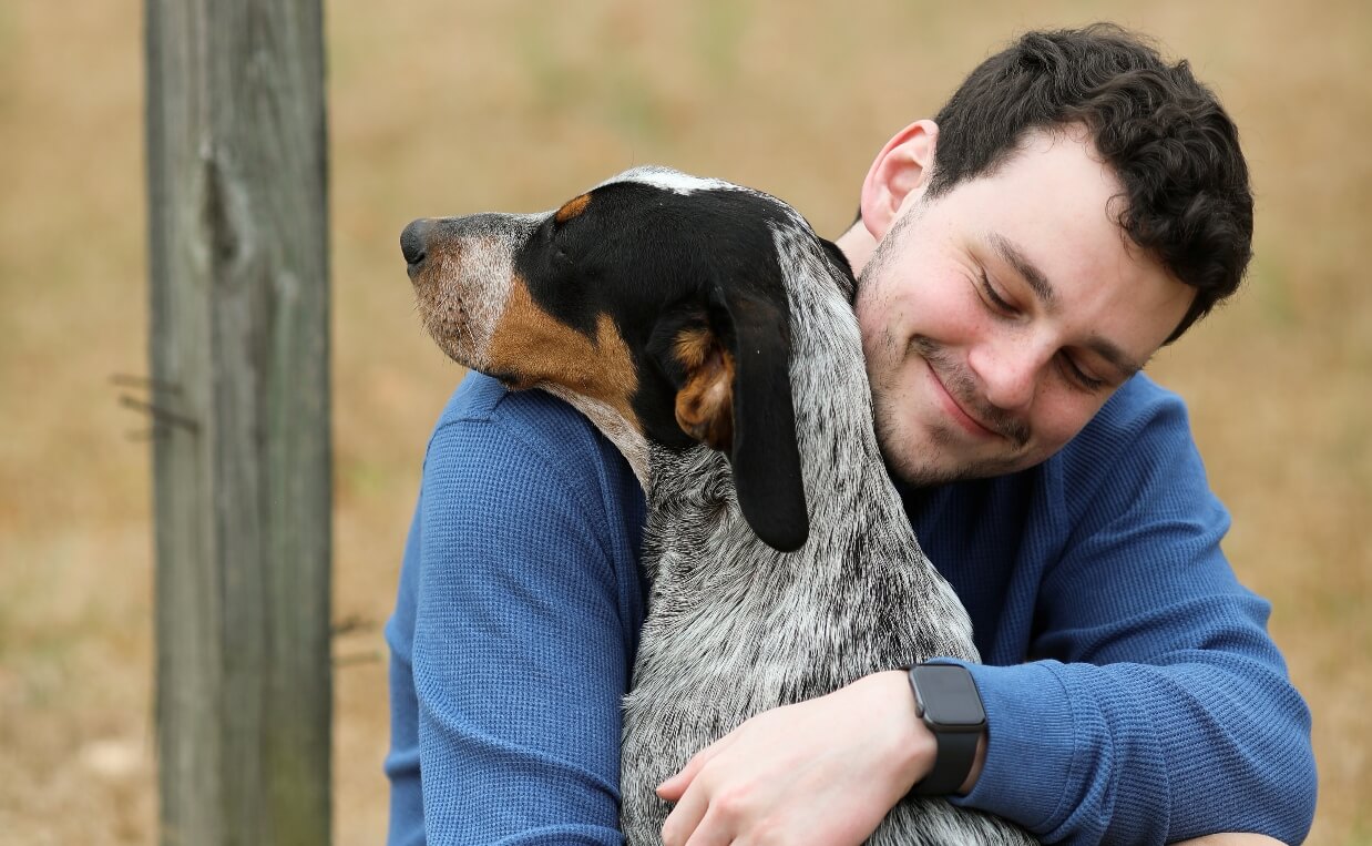 DOGS IN NEED HOLIDAY SEASON MAN HUGGING HUNTING DOG