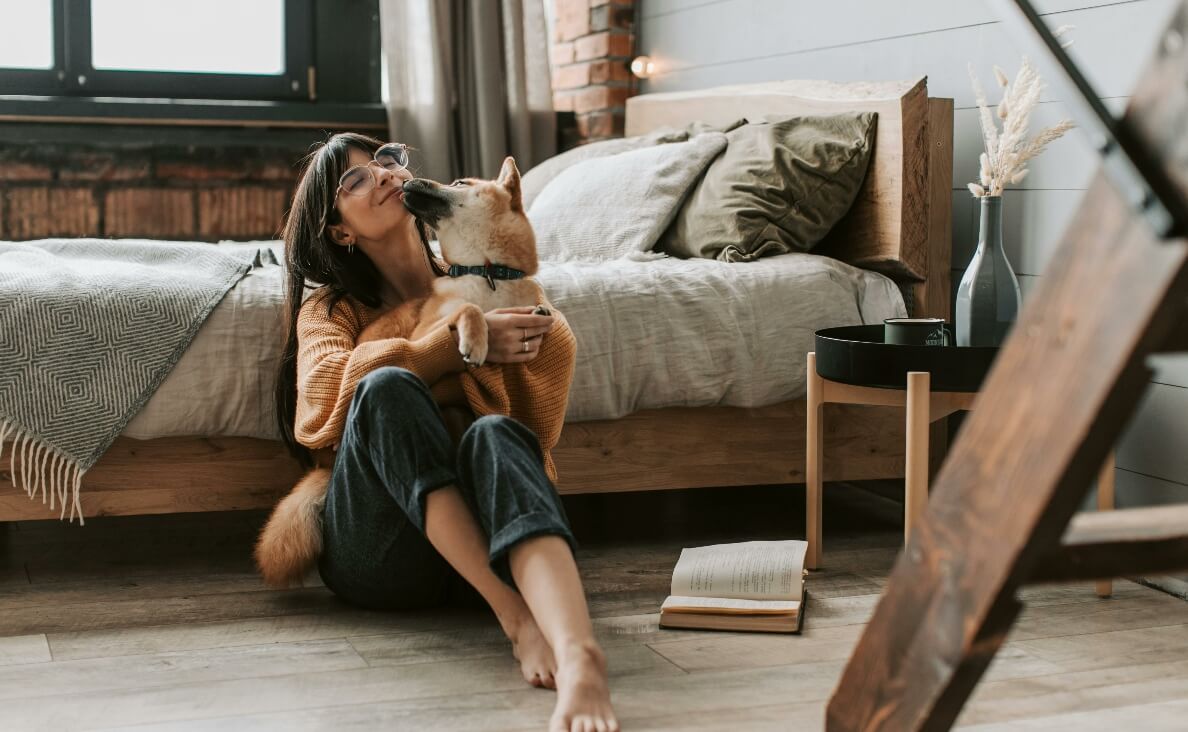 woman loving Shiba Inu dog and book next to her